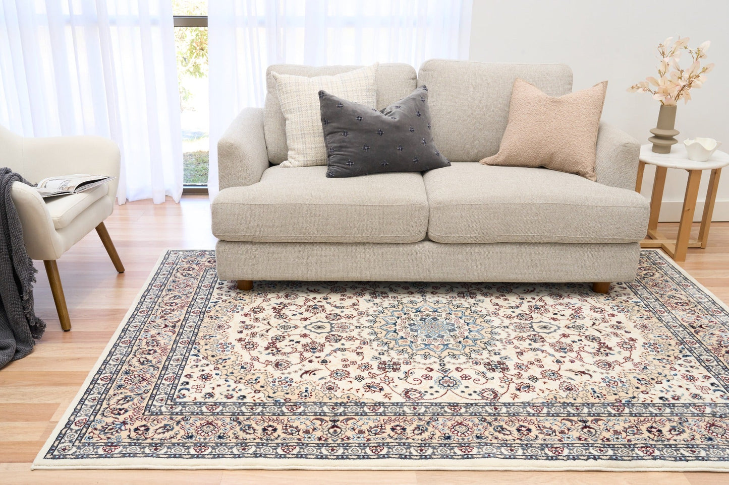 Ivory area rug with floral medallion pattern, blue border, and corner motifs