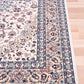 Ivory rug with central floral medallion and blue border at corner