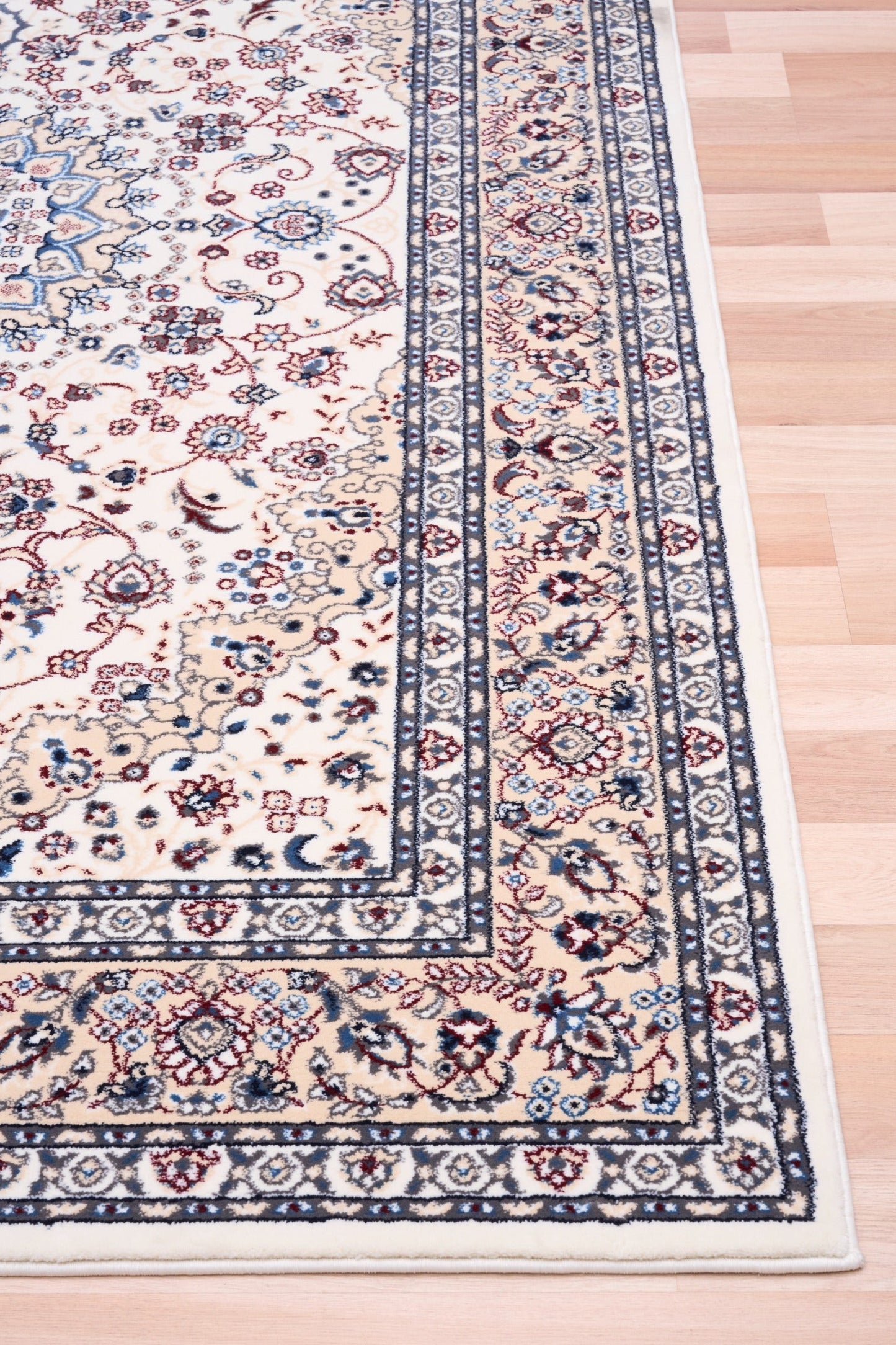 Ivory rug with central floral medallion and blue border at corner