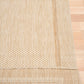 Beige rug corner showing layered edge and textured fabric close-up.
