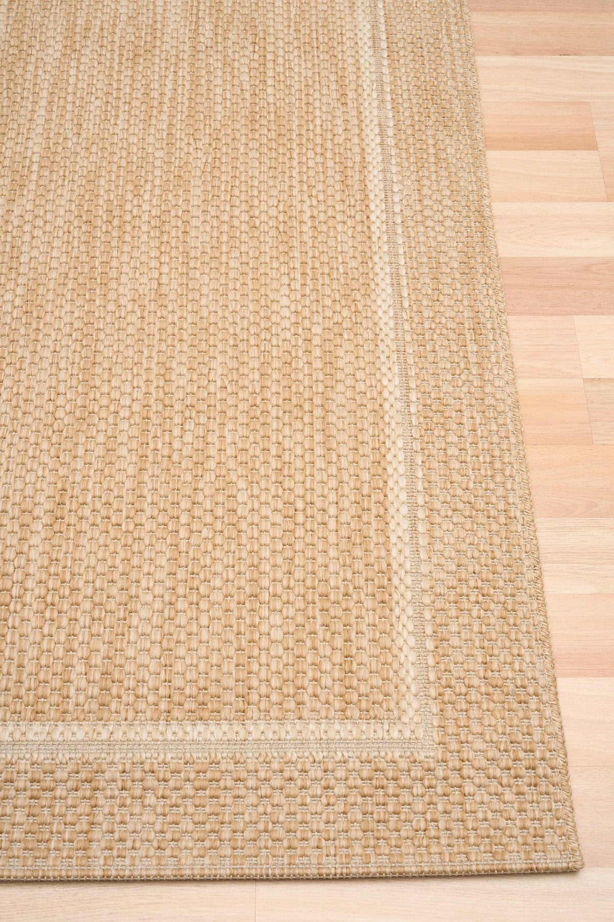 Beige flatweave area rug with border trim and inset square design