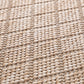 Close-up of beige woven rug texture with dense loop fibers.