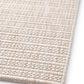 Beige woven area rug corner detail with tight dot-and-ridge texture pattern