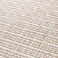 Beige woven rug close-up showing tightly packed looped fibers and ridged lines