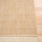 Woven area rug edge, light tan, flat weave with low-contrast grid pattern