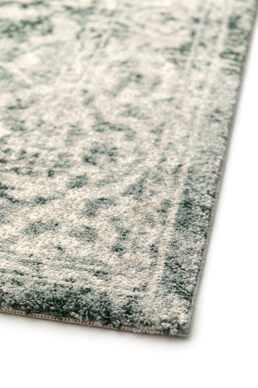 Rectangular rug corner with gray pile and teal-green distressed motifs, short border