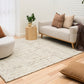 Beige textured area rug laid on light wood floor