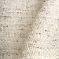 Beige textured area rug close-up with dense looped yarn and short fringe-free edge
