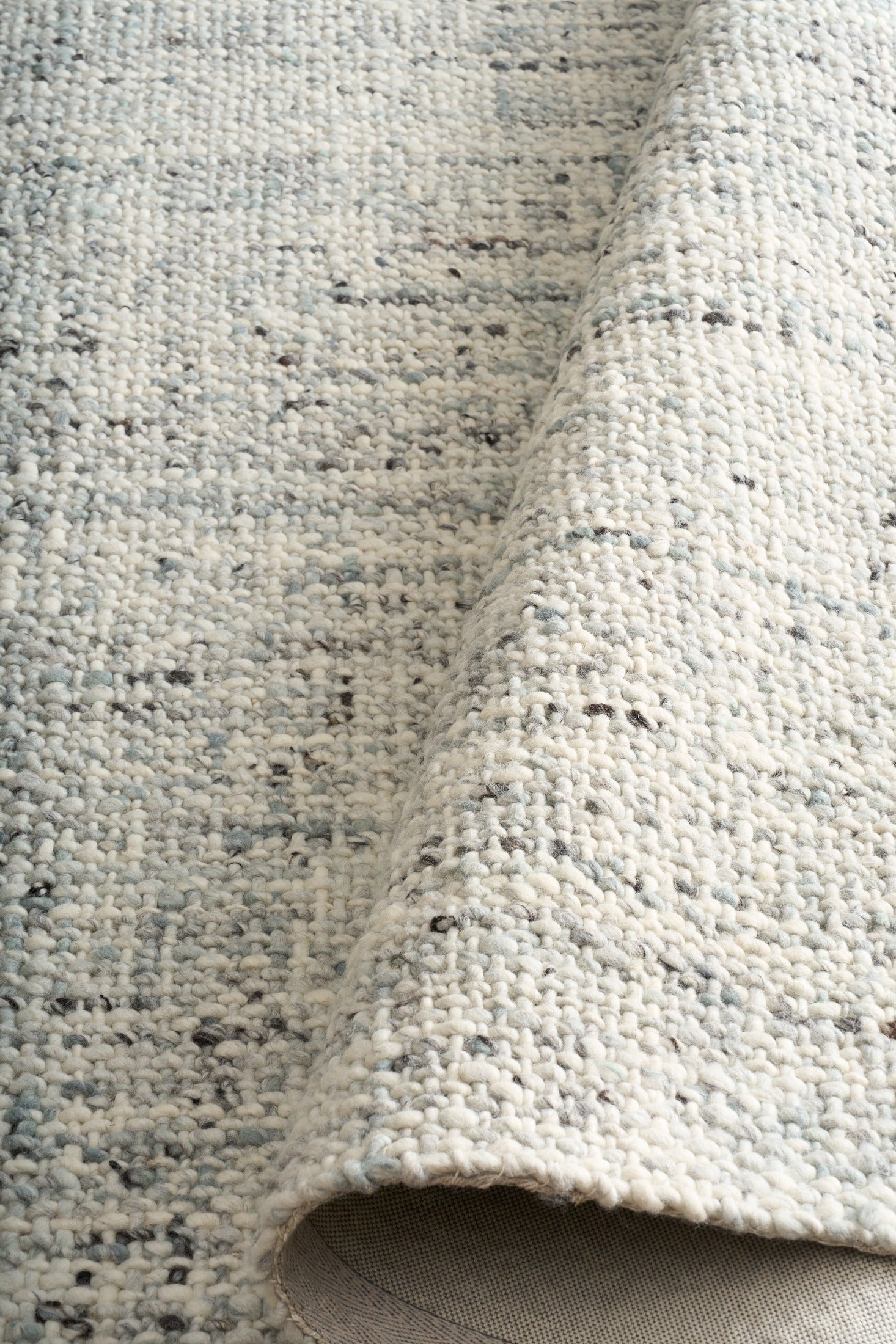 Cleo Blue textured area rug close-up, light blue speckled looped surface