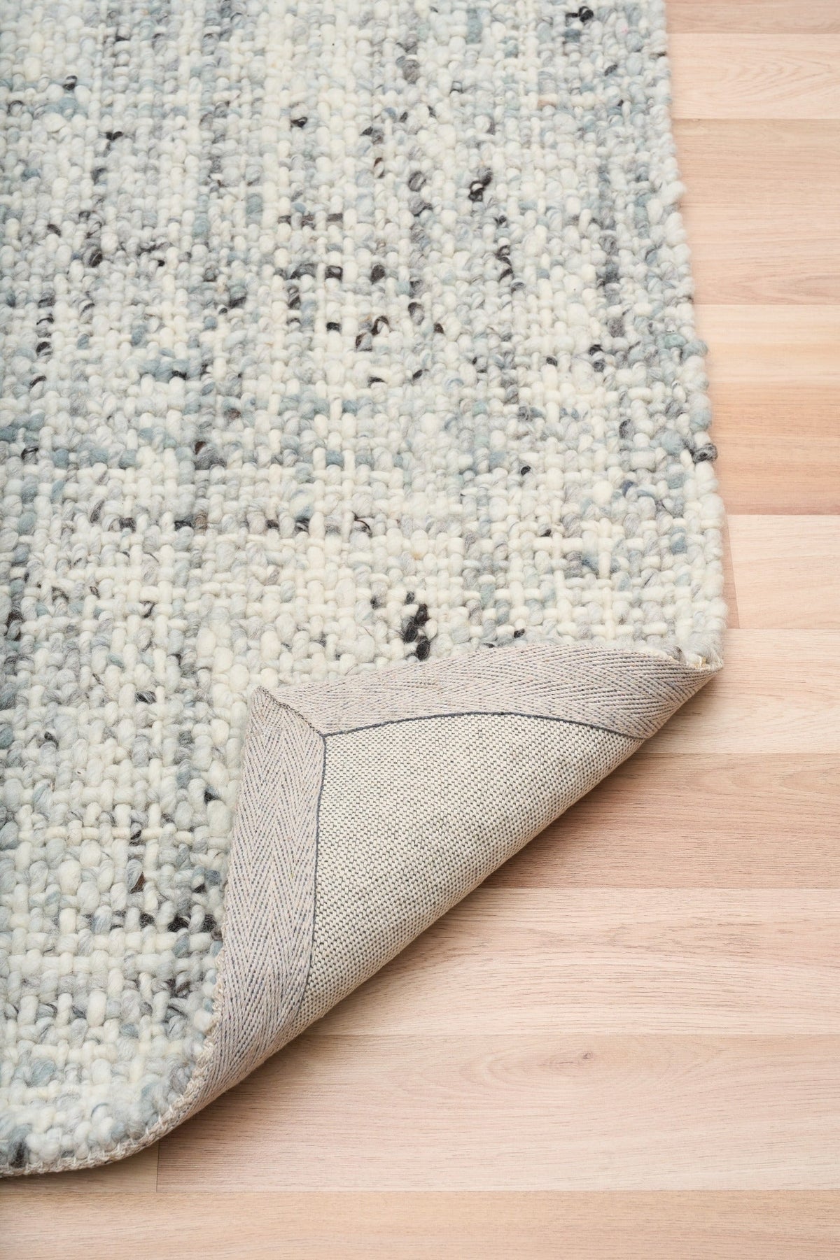 Cleo Blue textured area rug corner with light blue speckled pile and border