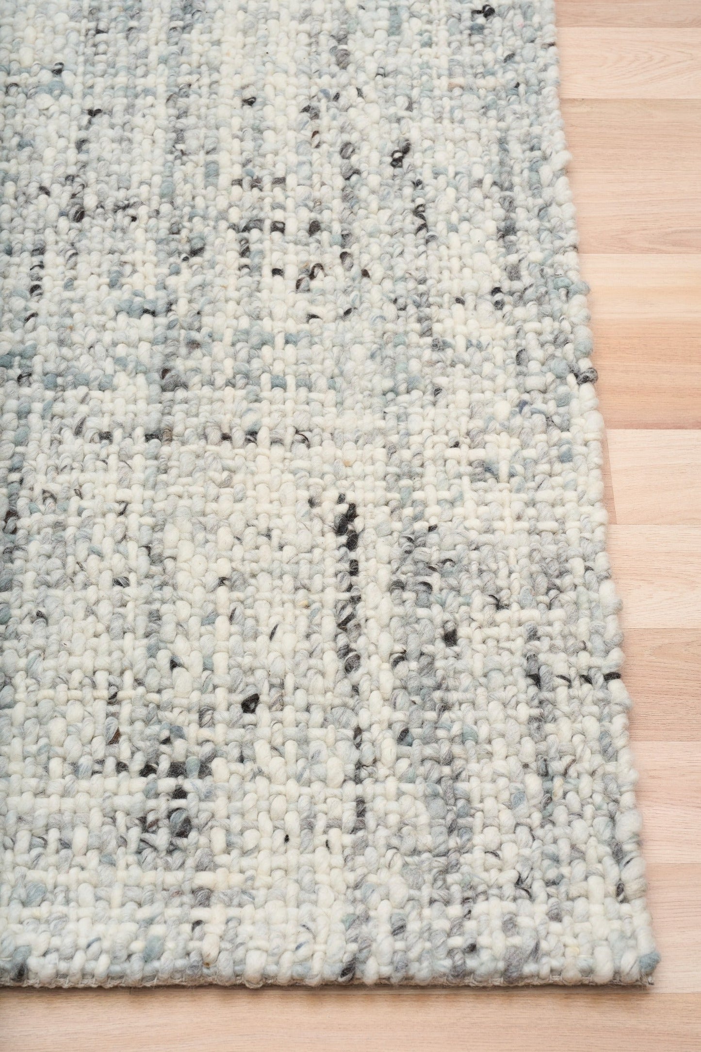 Cleo Blue textured area rug with light blue speckled weave and bound edge