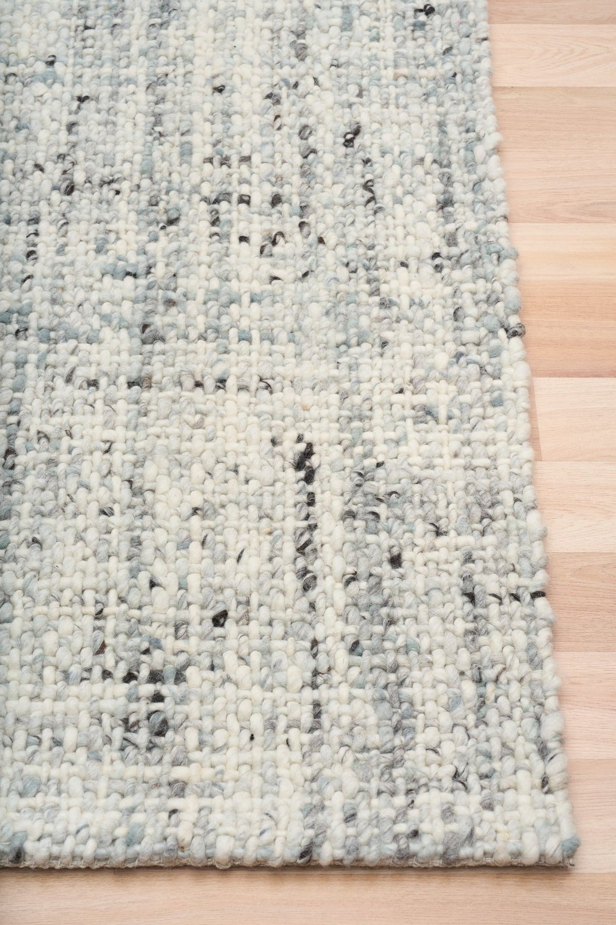 Cleo Blue textured area rug with light blue speckled weave and bound edge