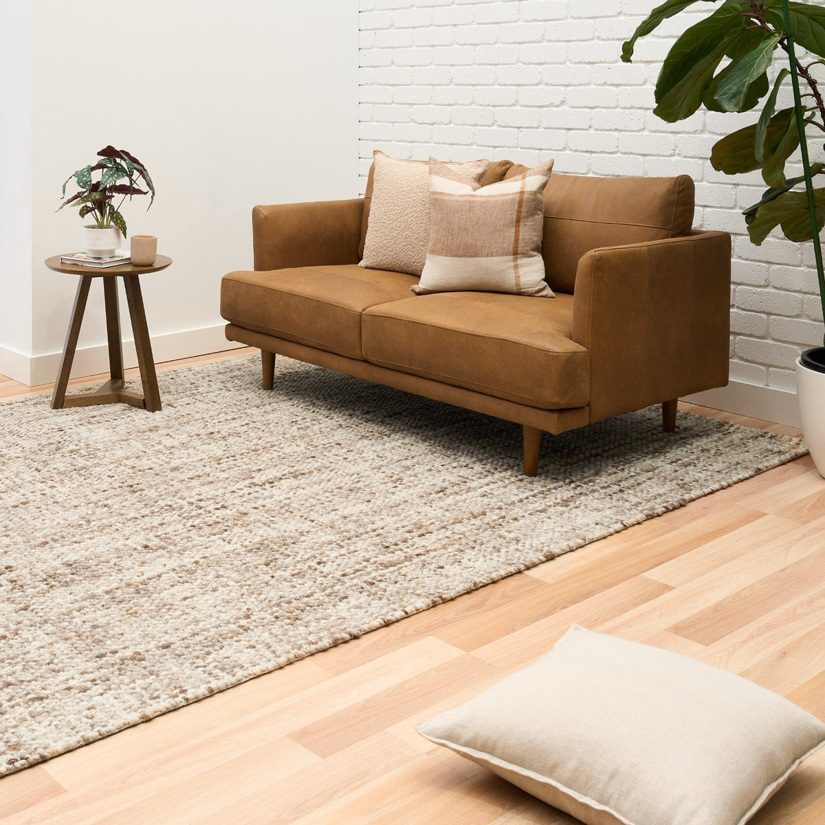 Large wool rug on hardwood floor, beige and brown speckled texture