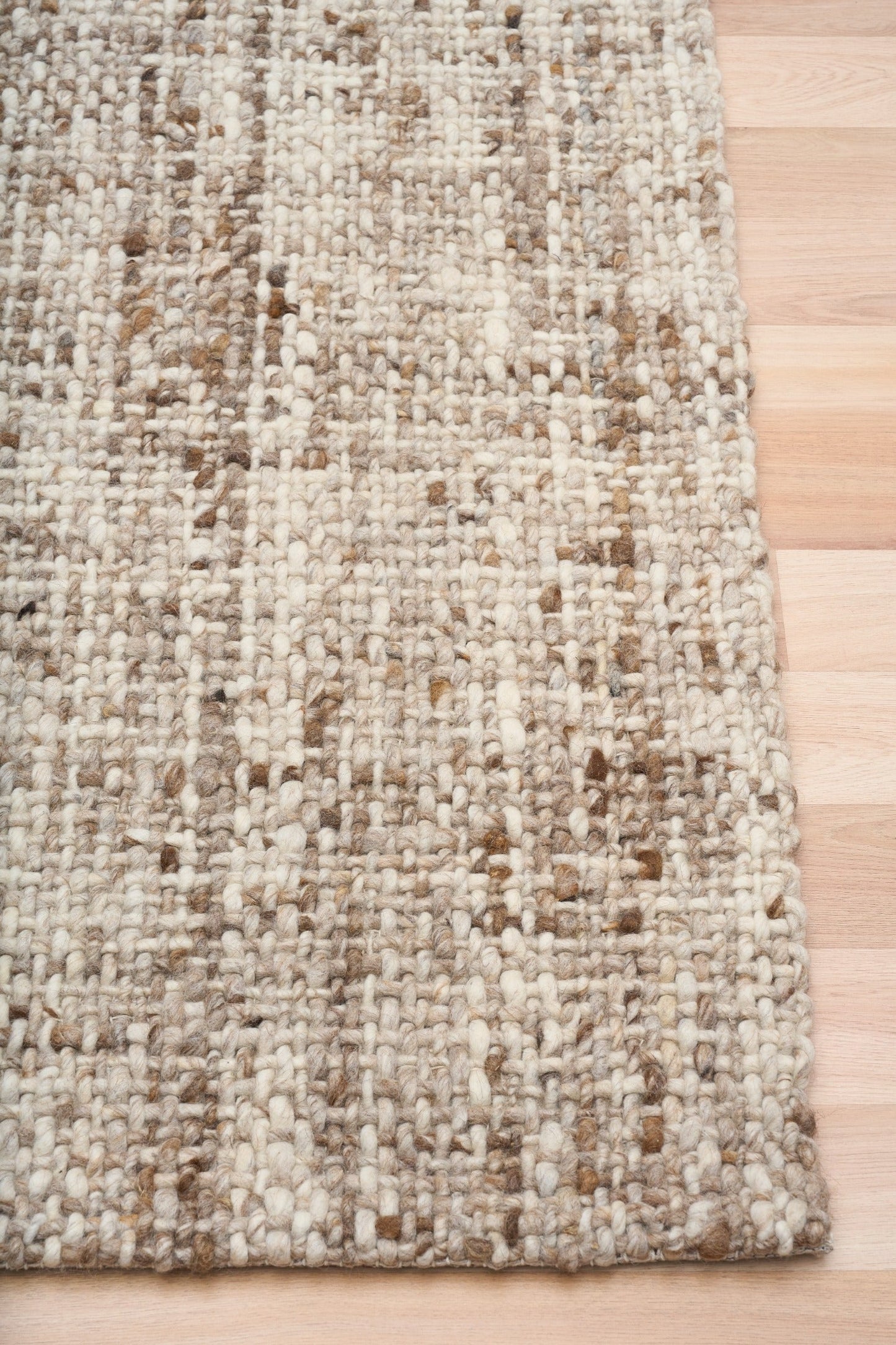 Wool area rug, beige with brown speckled weave and rounded edge