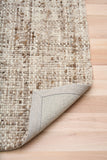 Wool rug with bound edge detail, beige underside on hardwood floor
