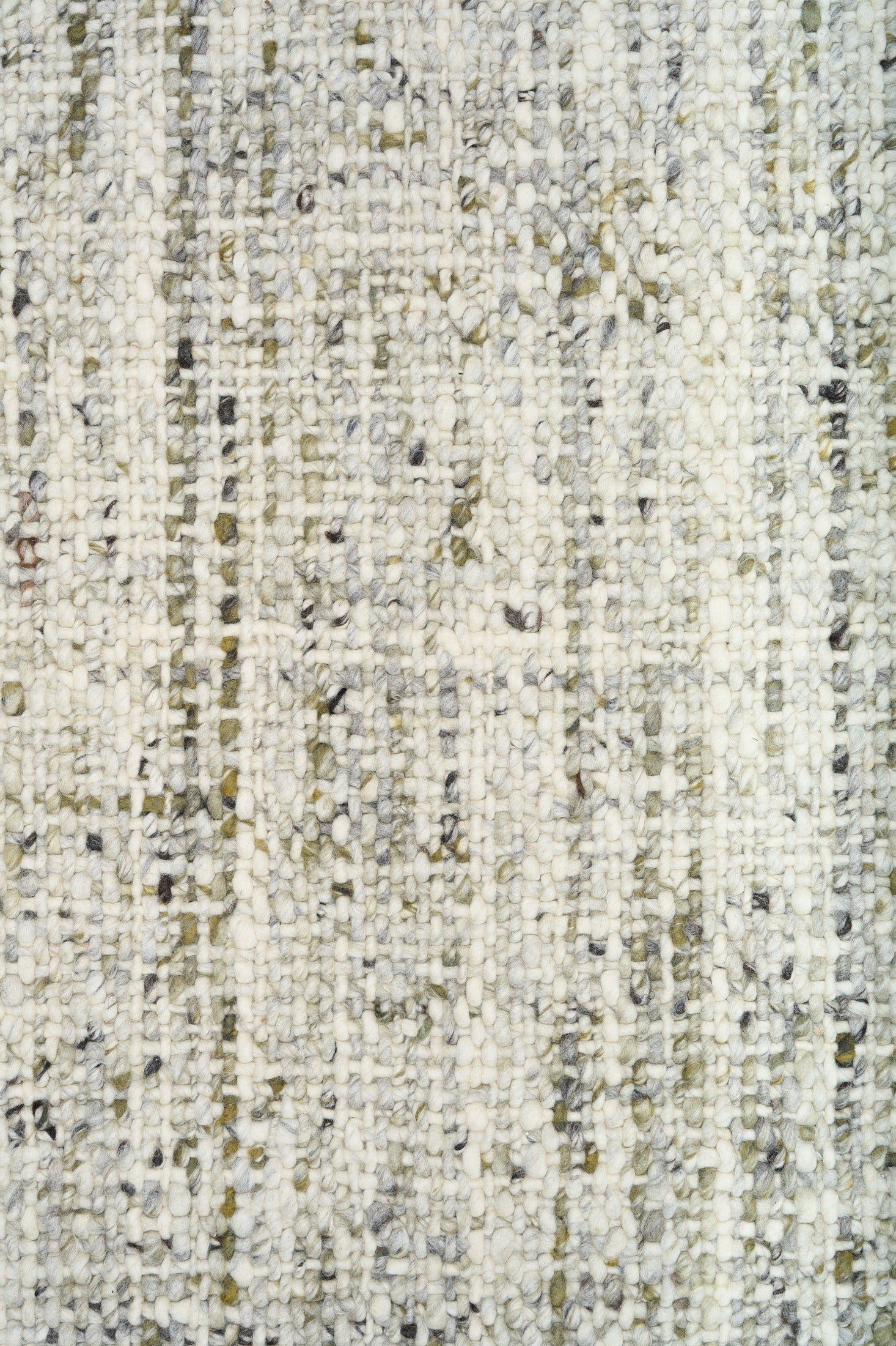 Ivory and light green speckled textured rug surface close-up