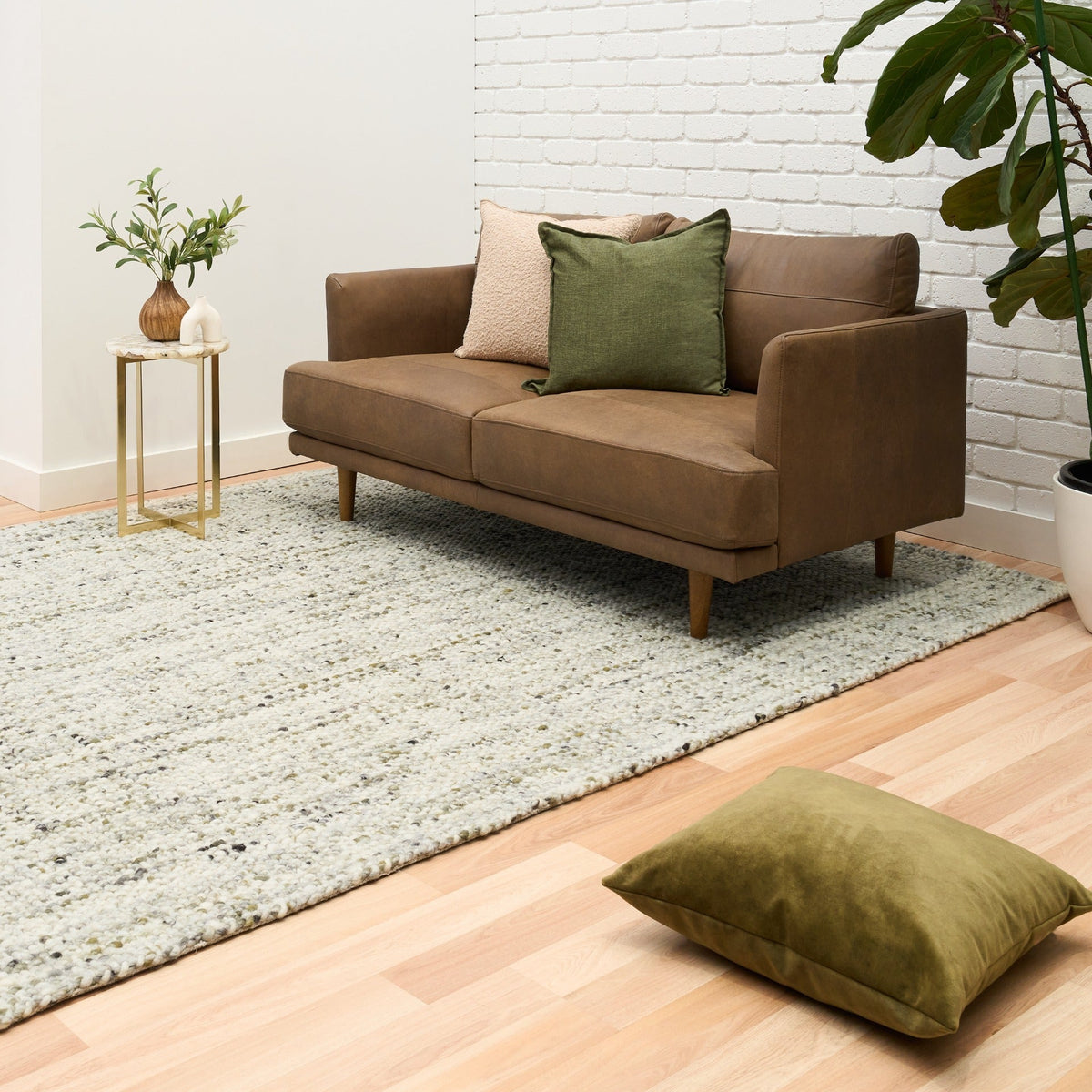 Ivory and light green textured area rug with short pile and speckled design