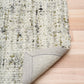 Ivory and light green textured rug corner with stitched border detail