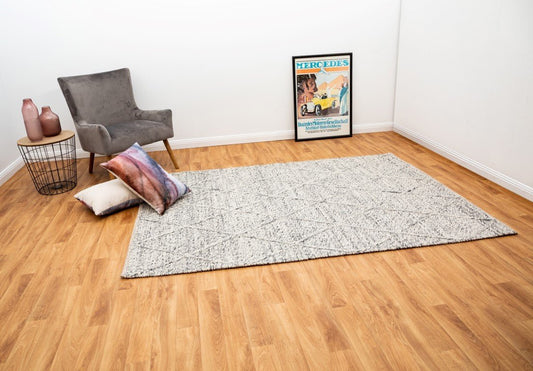 Grey wool area rug with distressed geometric pattern.