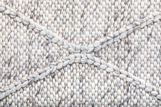 Light grey wool rug close-up with geometric trellis weave pattern