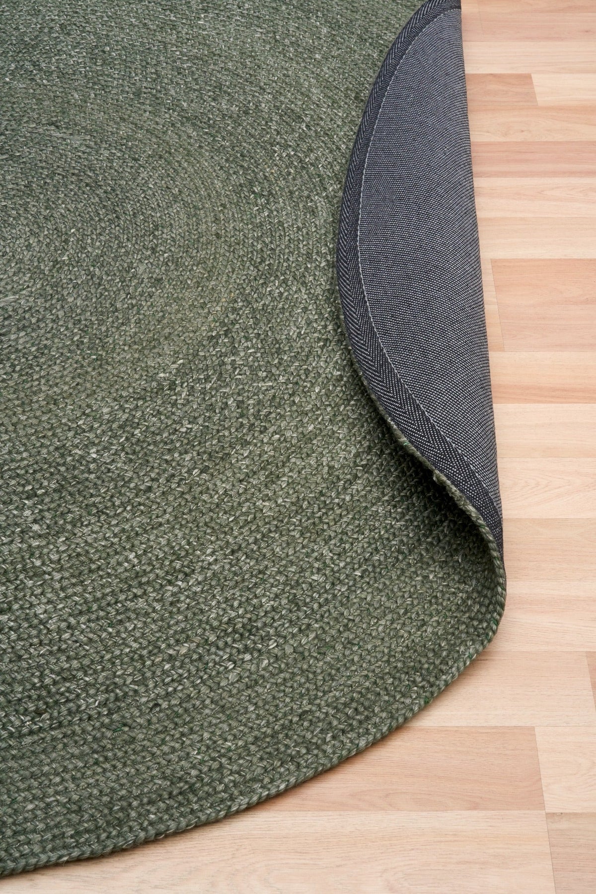 Olive green round rug with gray anti-slip backing and stitched edge