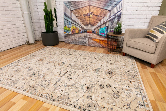 Ivory-beige area rug with ornate distressed pattern and low pile texture