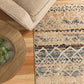 Blue and beige abstract area rug partially visible under light sofa and near round table
