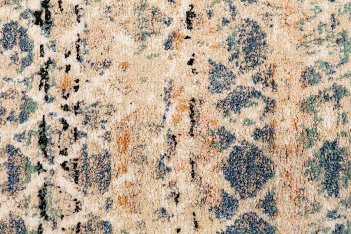 Close-up of blue, beige, and cream abstract rug texture with speckled motifs
