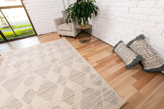 Ivory-beige area rug on wood floor with geometric diamond motif