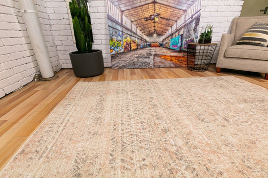 Beige abstract area rug with distressed pattern, laid flat
