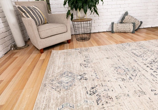 Dark beige area rug with distressed geometric pattern and navy accents