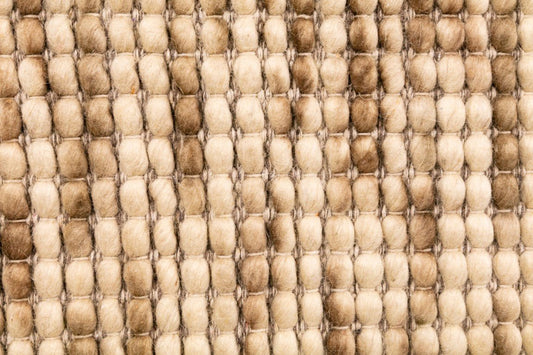 Close-up of natural wool rug with looped pile in beige and light brown