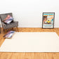 Cream wool rug rectangular with dense textured weave, laid flat on wood floor