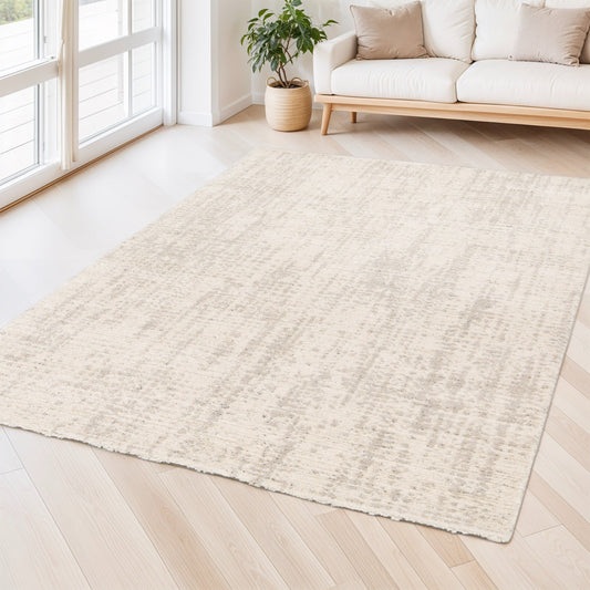 Cream area rug with low pile texture laid on hardwood floor