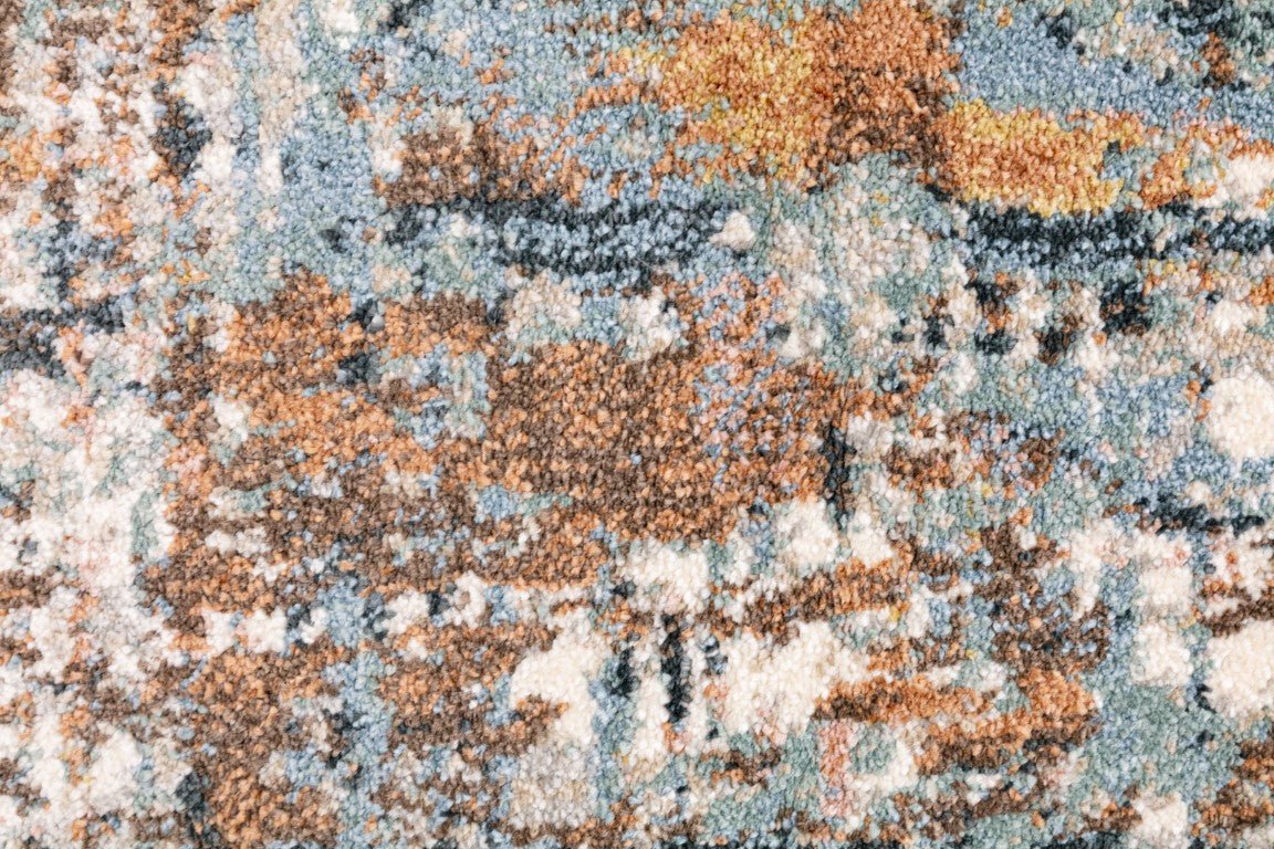 Textured abstract rug surface with speckled blue, orange, and cream tones