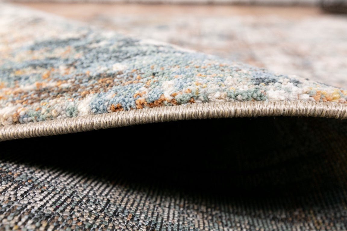 Rug edge detail showing low pile and woven border in blue-gray