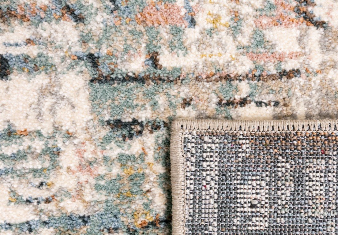 Corner border of multi-color abstract rug with woven fringe and textured weave