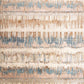 Beige area rug close-up with blue and tan abstract distressed pattern