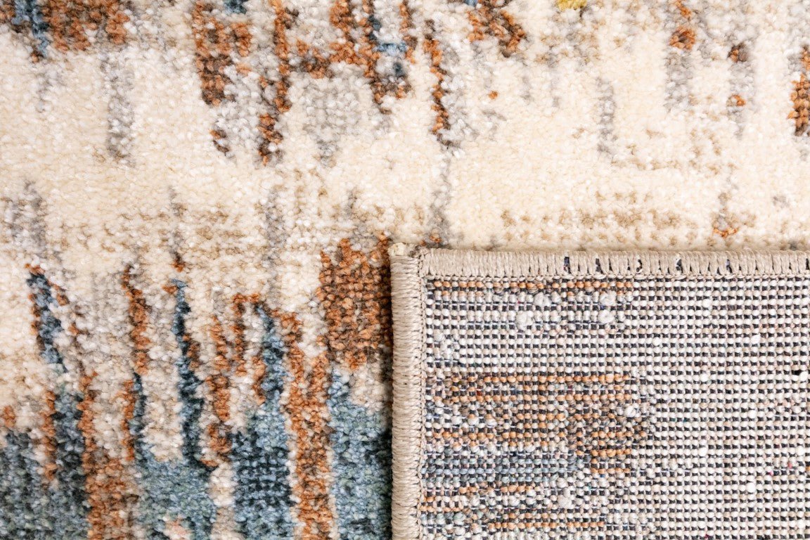Beige area rug corner detail with blue and rust pattern and border stitching