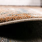 Beige area rug edge detail with tightly looped pile and stitched border