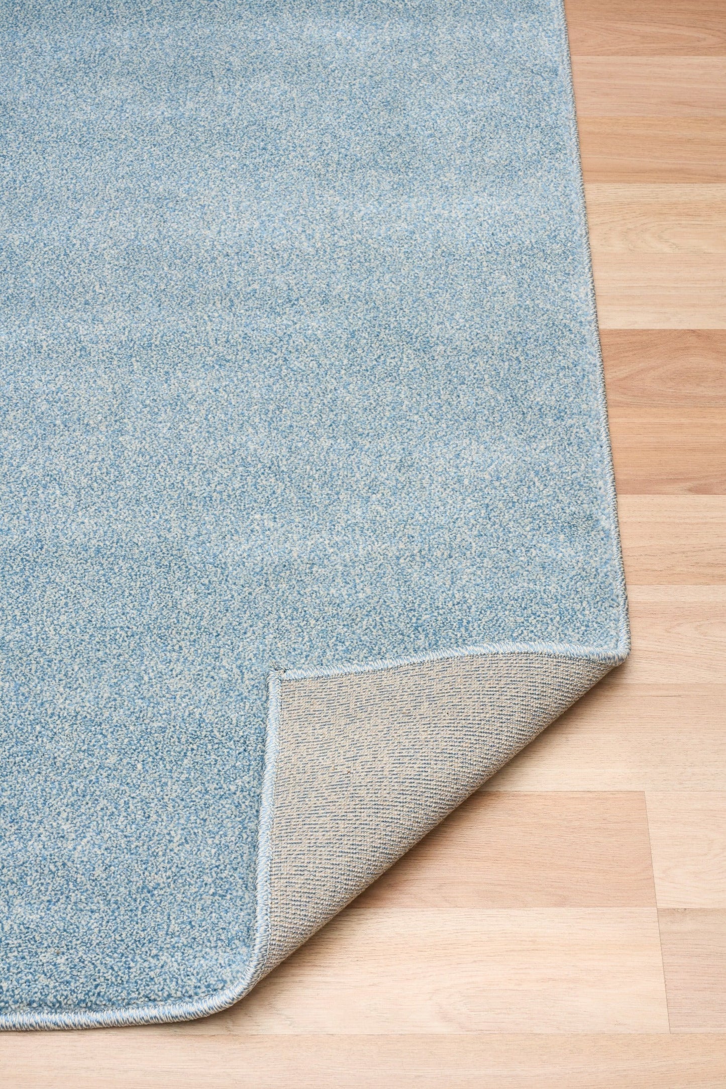Blue speckled area rug showing folded corner and underside backing. | Eclipse Katana Modern Abstract Polypropylene Area Rug - Rugs Point Australia