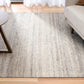 Dark grey wool rug in living room setting with table and sofa visible at edges