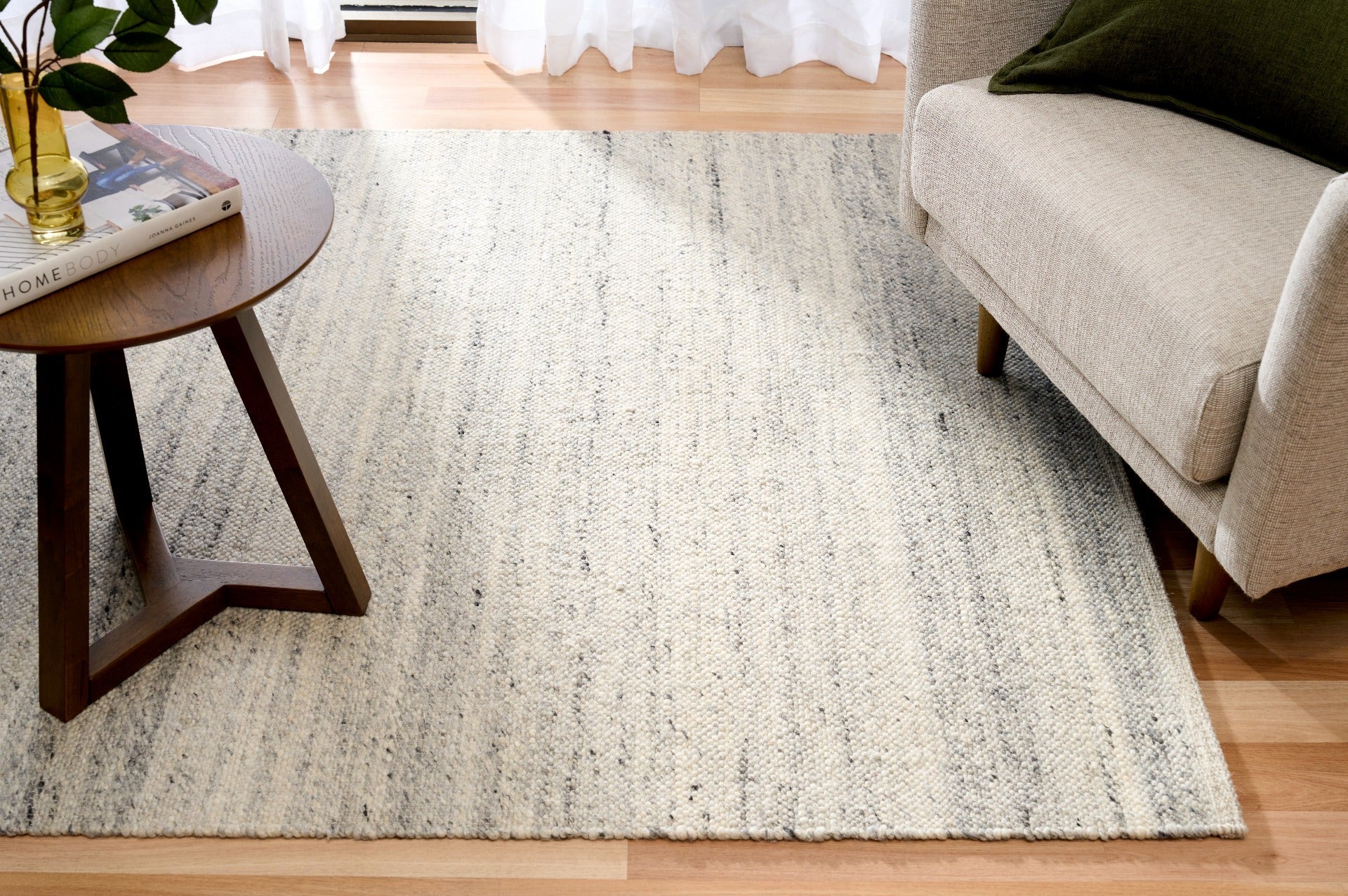 Grey wool area rug full view with textured speckled surface and horizontal bands
