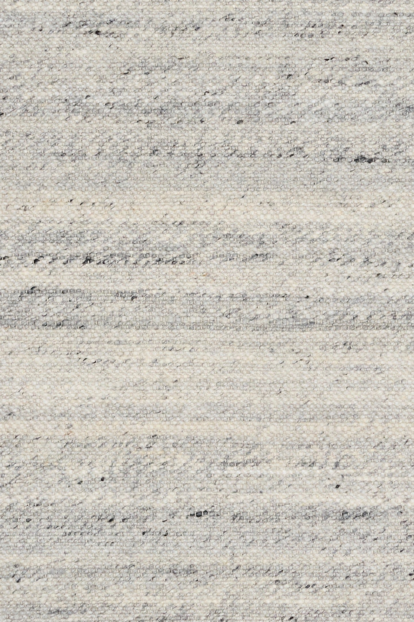 Grey wool rug close-up showing speckles and thin horizontal stitched lines