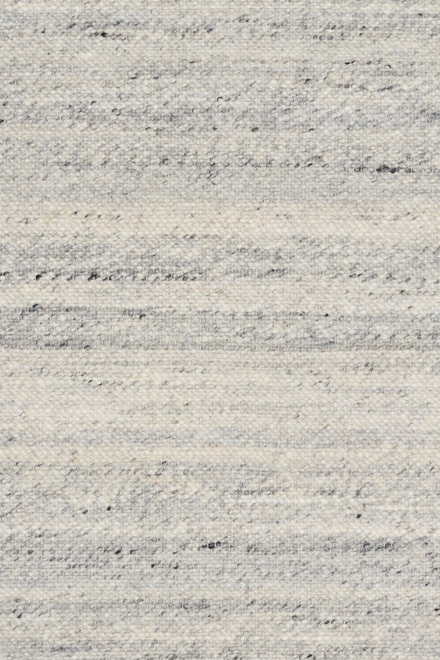 Grey wool rug close-up showing speckles and thin horizontal stitched lines