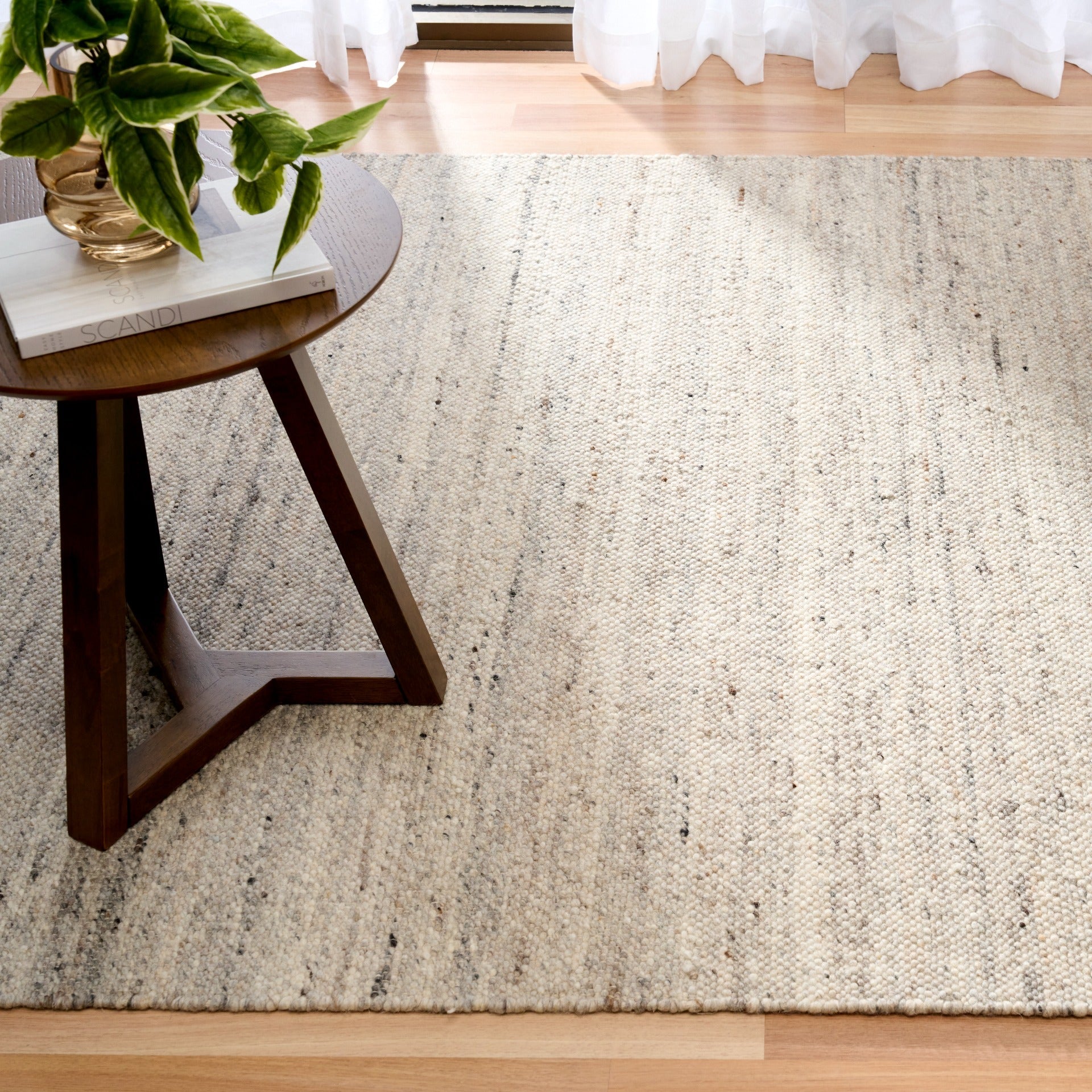 Smoke grey wool rug with speckled woven surface, angled view showing clean edges