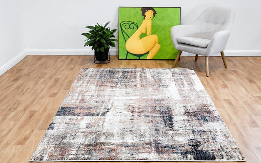 Beige contemporary area rug with abstract navy, orange, and blue distressed pattern