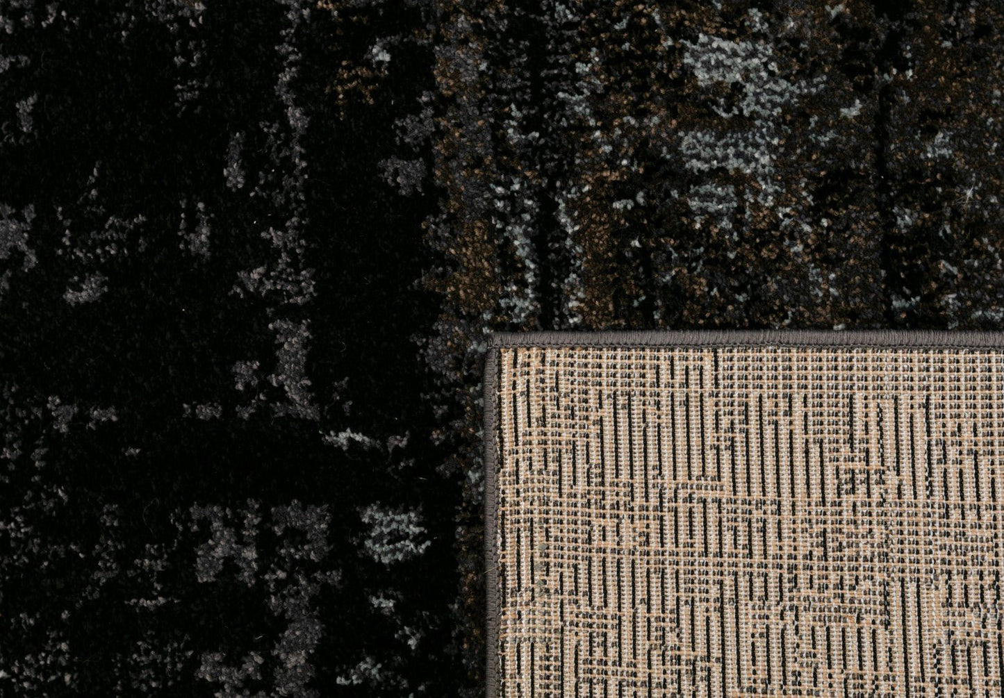 Black area rug corner detail with woven light backing trim