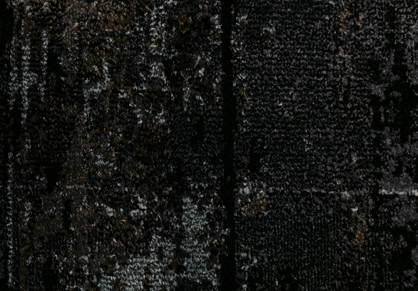 Black area rug close-up with grainy mottled gray speckles