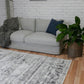 Grey patterned area rug with distressed geometric motif